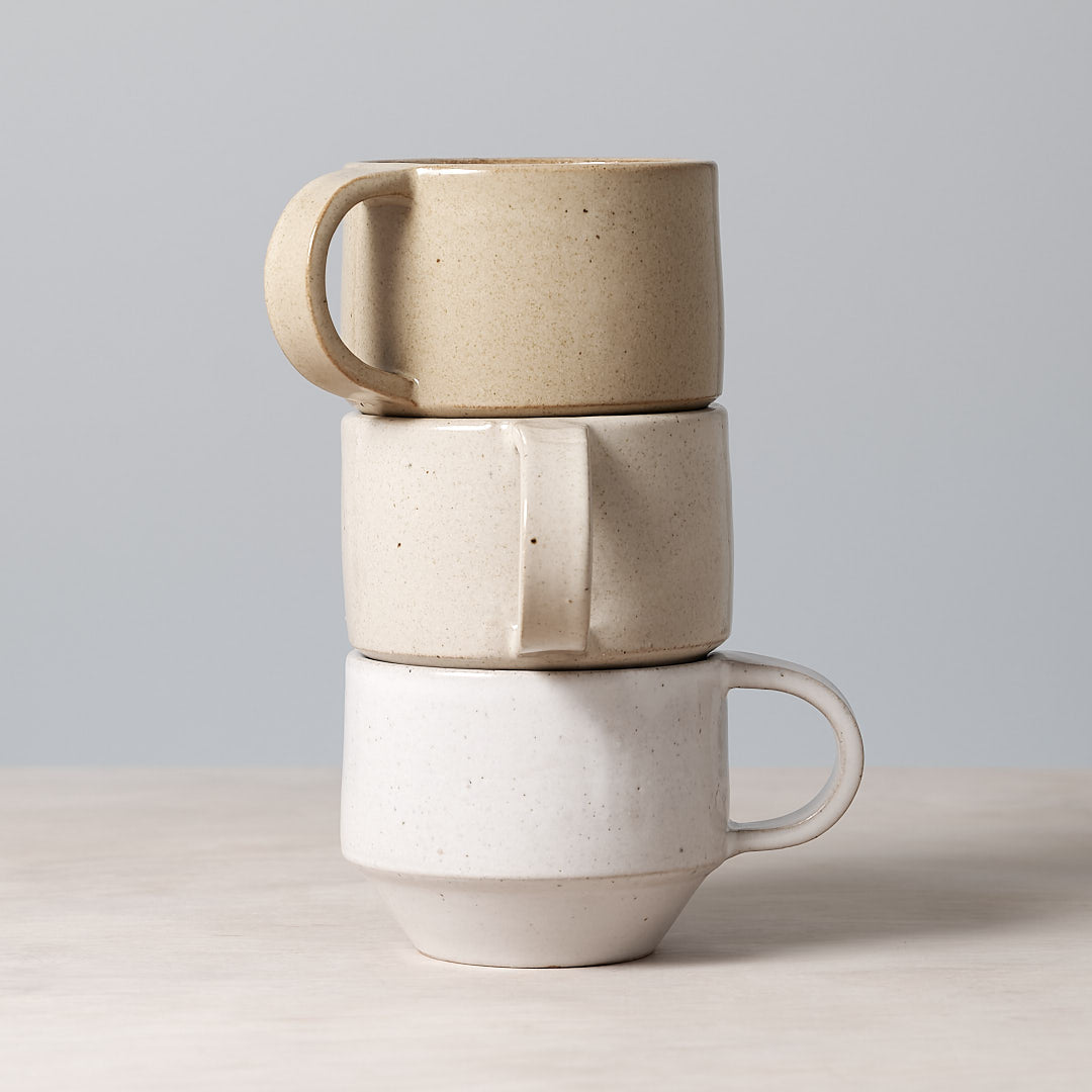 A stack of three Richard Beauchamp C-handled Stacking Mugs – Sand, dishwasher safe.