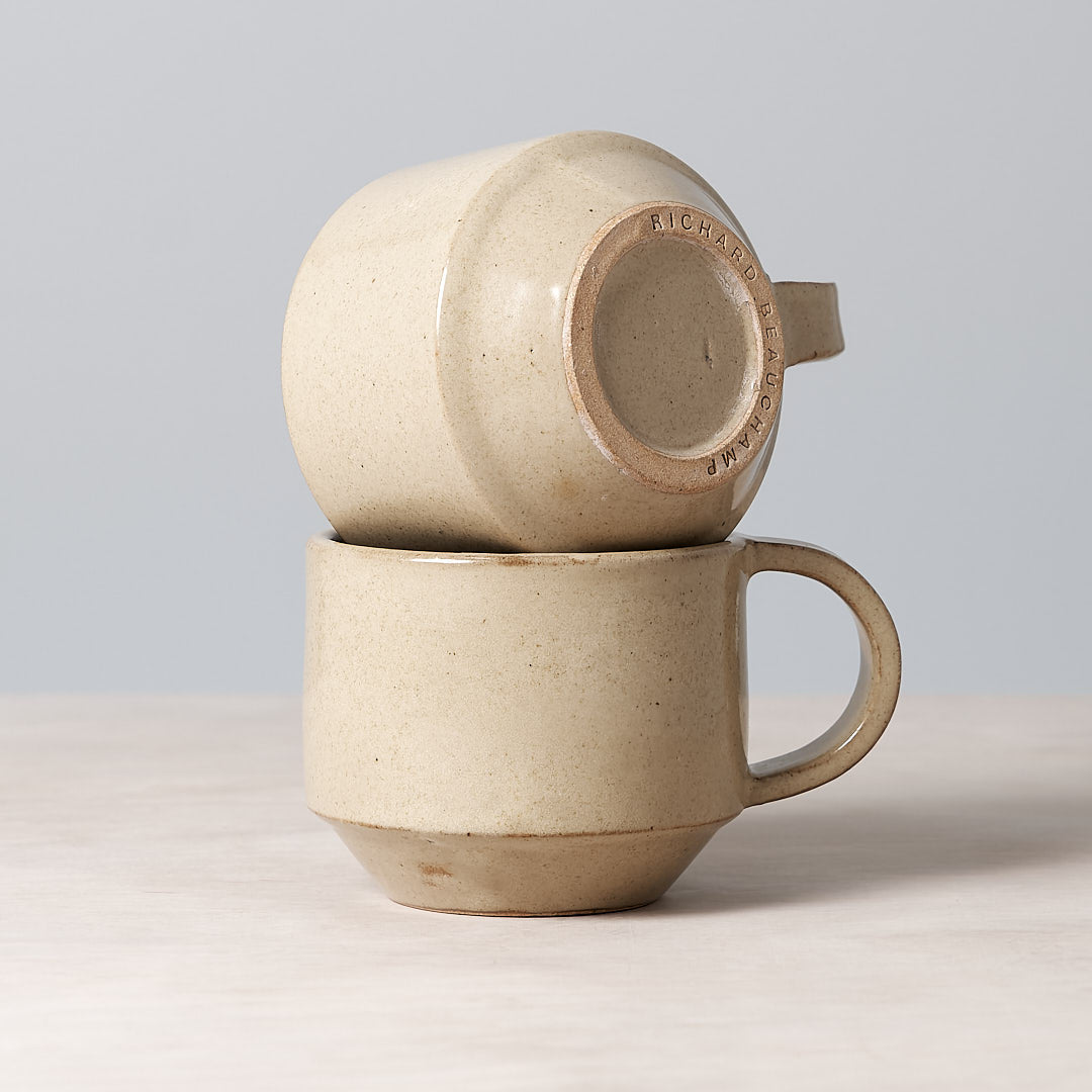 A stack of two C-handled Stacking Mugs in Sand color, handmade and dishwasher safe, by Richard Beauchamp.