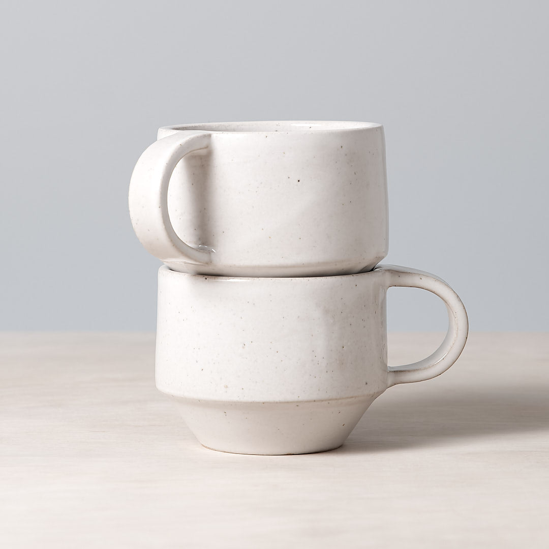 Two Richard Beauchamp C-handled Stacking Mugs – White stacked on top of each other.