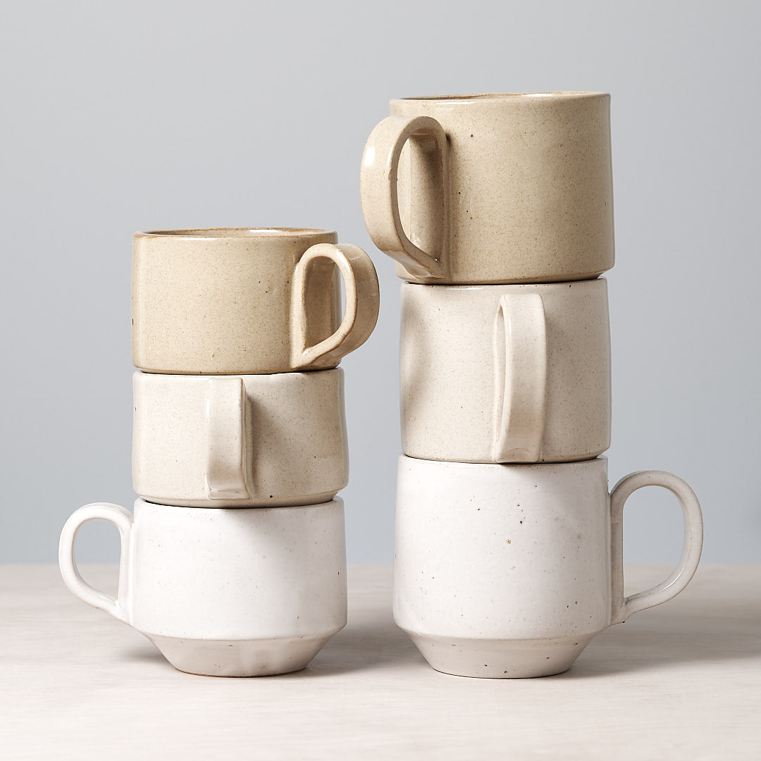 Four Large Stacking Mugs – Sand by Richard Beauchamp stacked on top of each other.