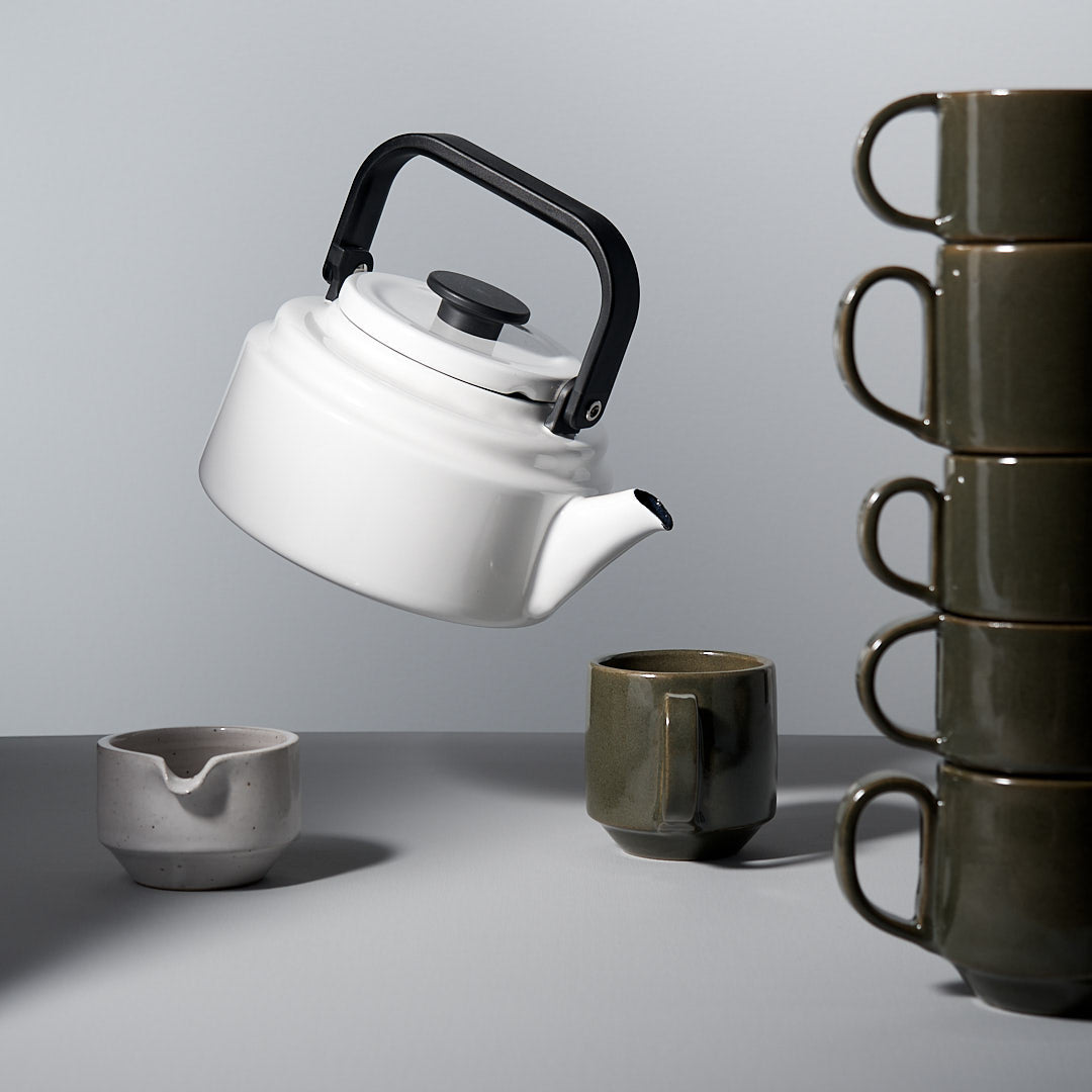 A stack of Richard Beauchamp C-handled Stacking Mugs – Green and a teapot.