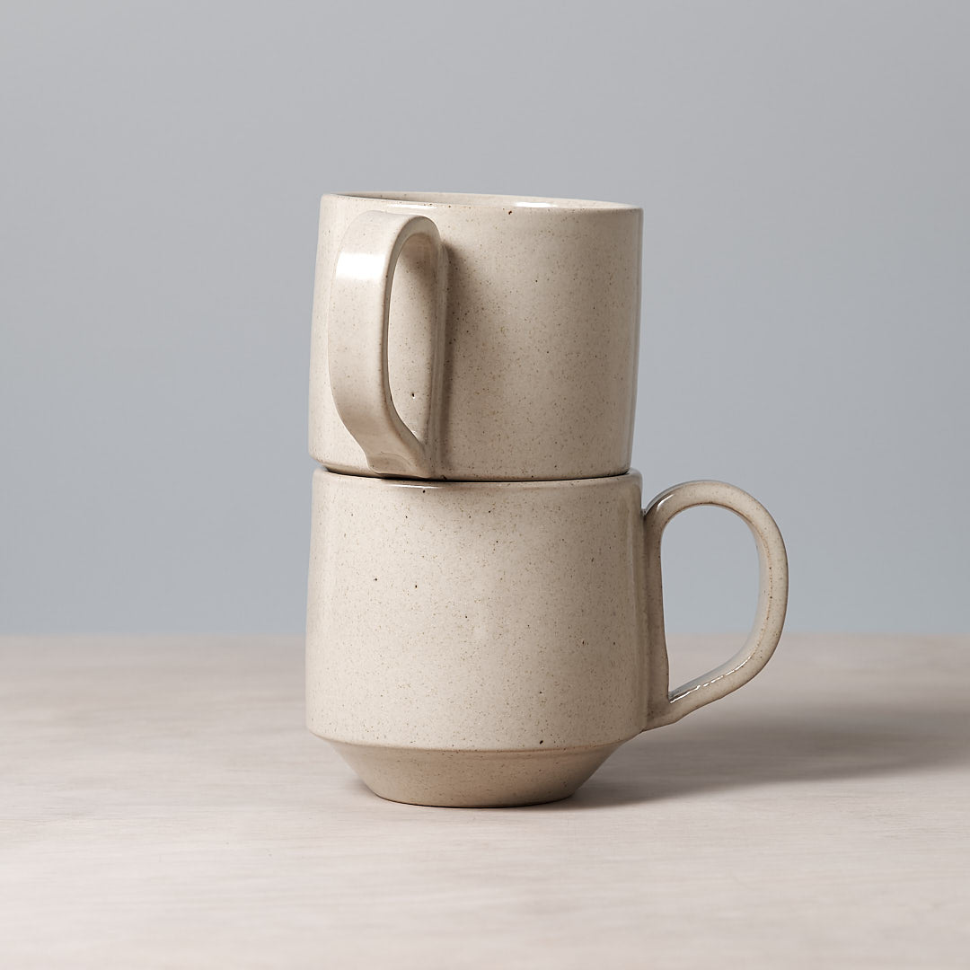 Two Large Stacking Mugs - Beige by Richard Beauchamp stacked on top of each other.