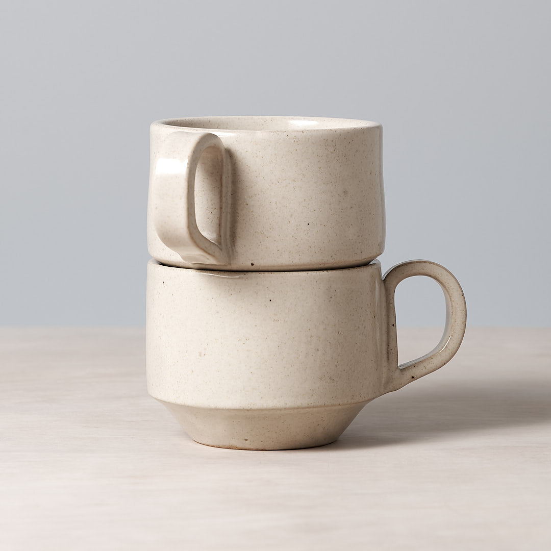 Two Richard Beauchamp Medium Stacking Mugs – Beige stacked on top of each other.