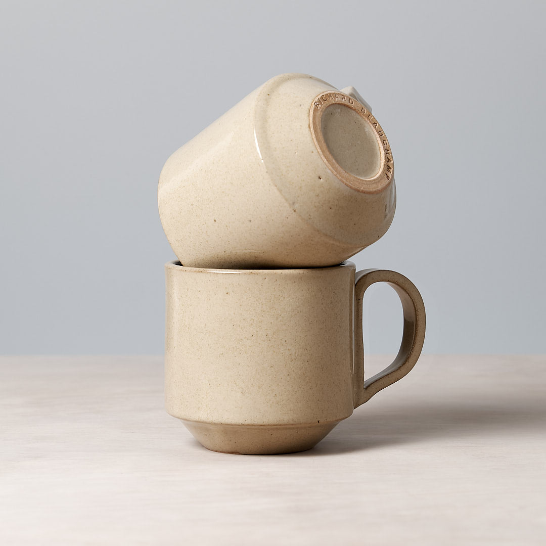 Two Richard Beauchamp Large Stacking Mugs - Sand sitting on top of each other on a table.