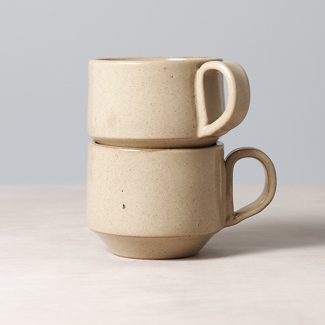 Two Medium Stacking Mugs - Sand, made by Richard Beauchamp, stacked on top of each other.