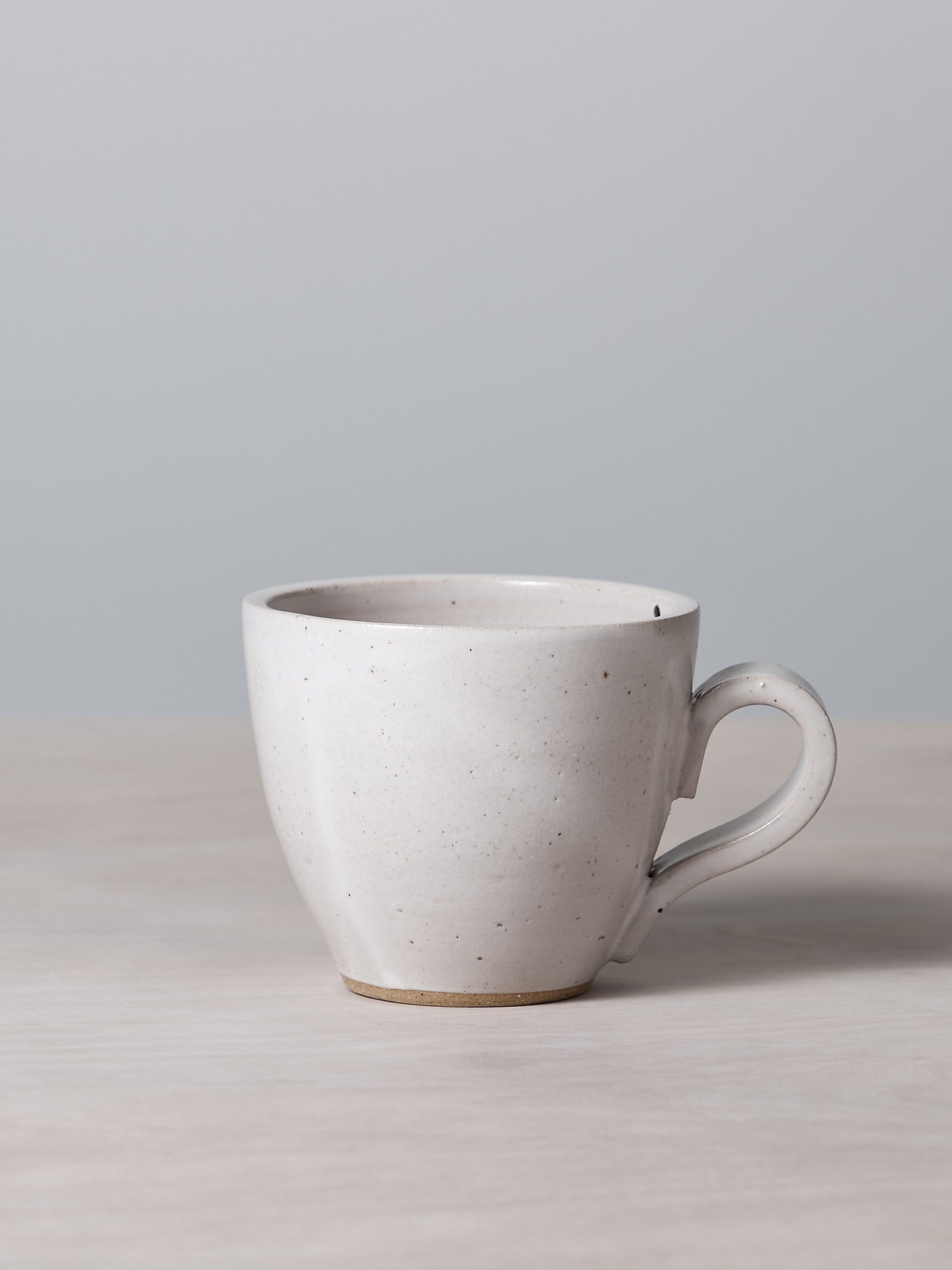 A Richard Beauchamp Tulip Cup – White with a satin glaze sitting on a table