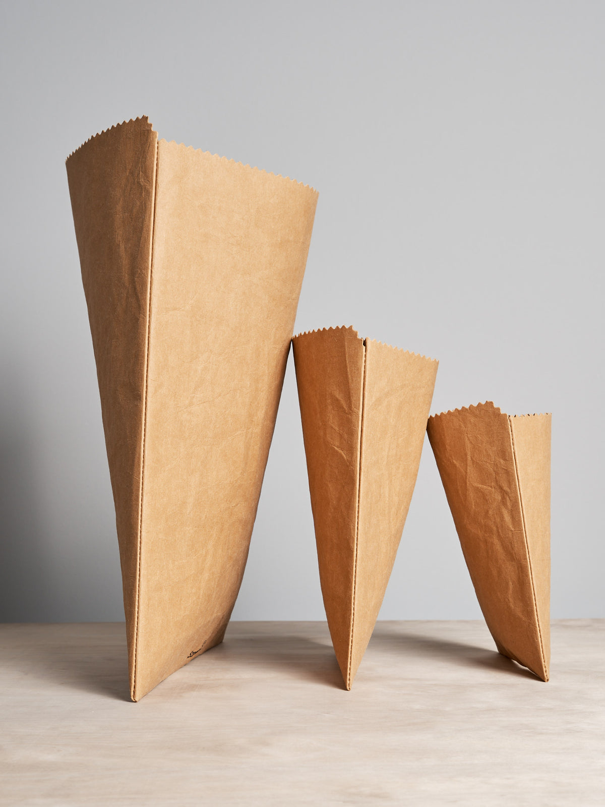 Three Sammy Bags Reusable Flat Bag – XL on a wooden table.