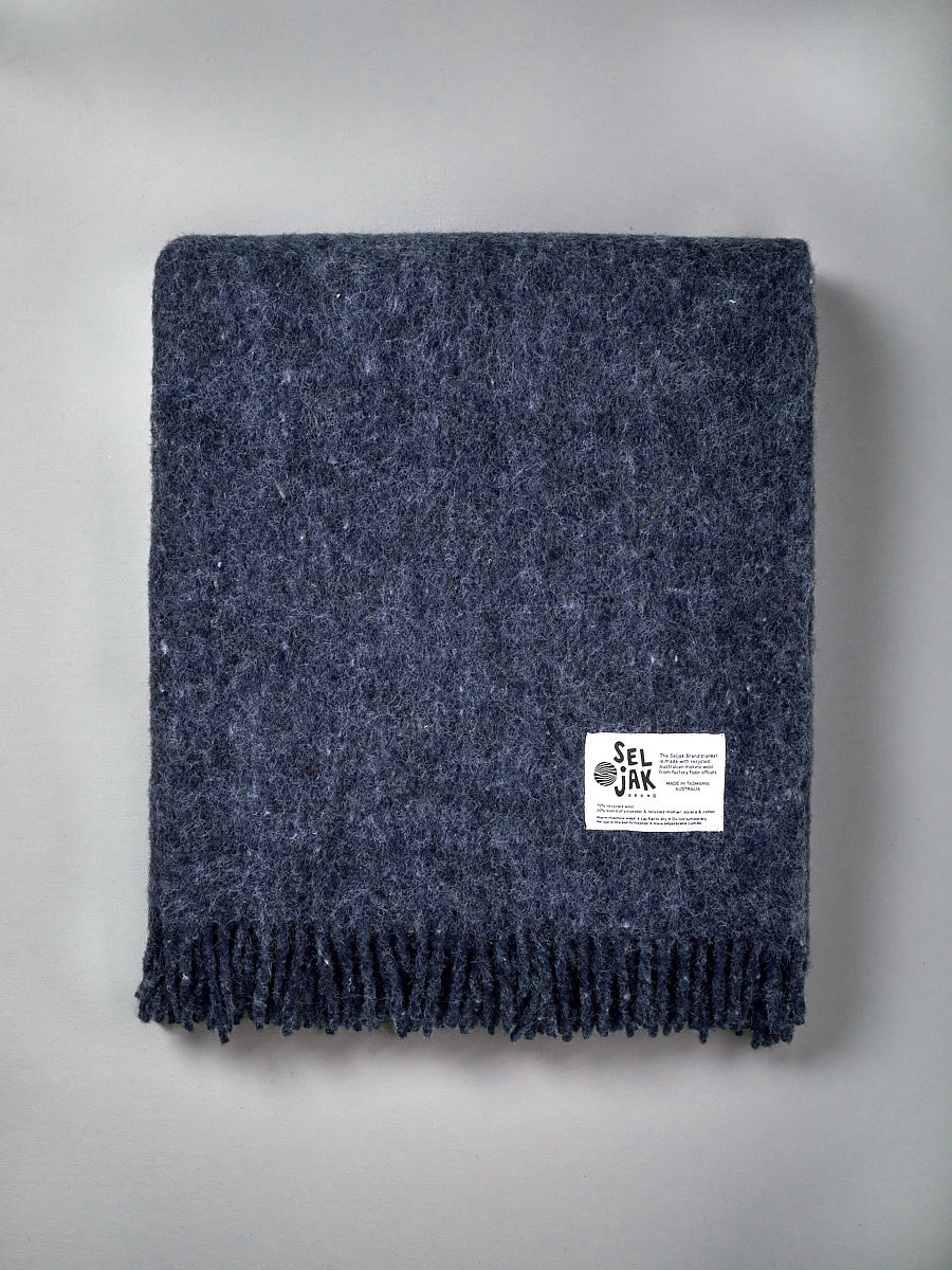 A Seljak Brand Indigo Blanket – Fringe with a label on it.