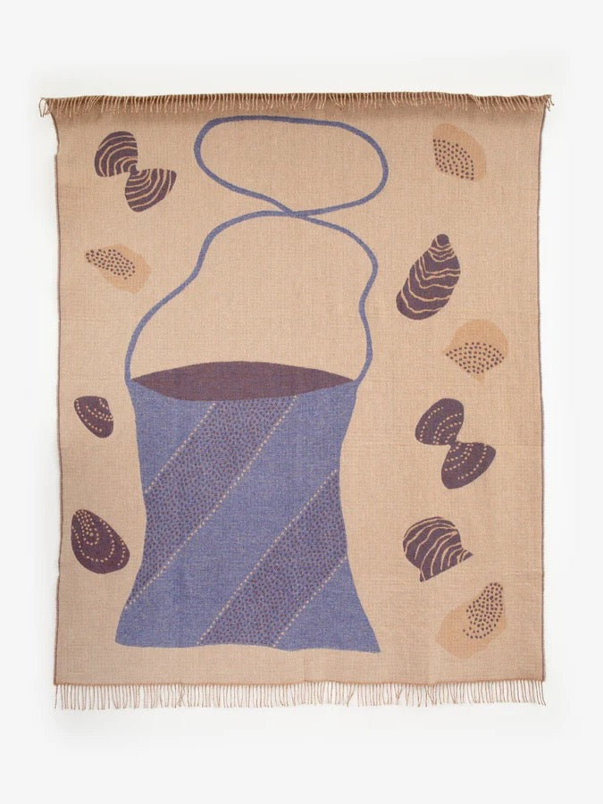 A Gather Blanket from Seljak Brand, with shells on it.