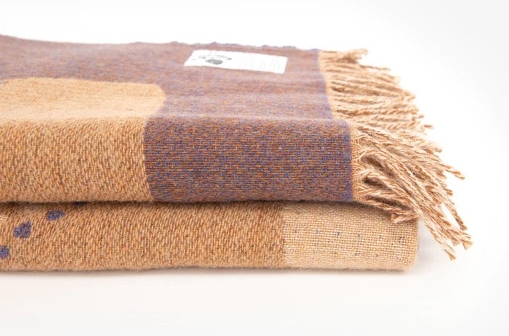 Two Gather Blankets by Seljak Brand, one brown and one blue, on top of each other.