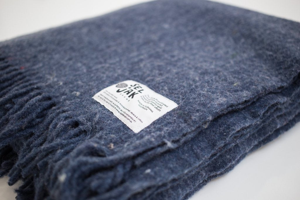 A Indigo Blanket – Fringe with a label on it.