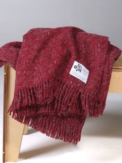 A Pinot Blanket - Fringe by Seljak Brand on a wooden bench.