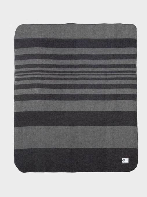 A Moontide blanket from Seljak Brand, featuring grey and black stripes on a white background.