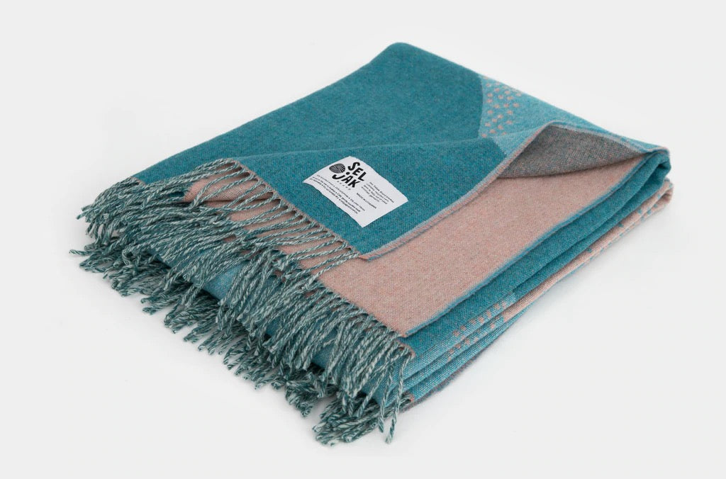 A Passage Blanket by Seljak Brand with fringes.