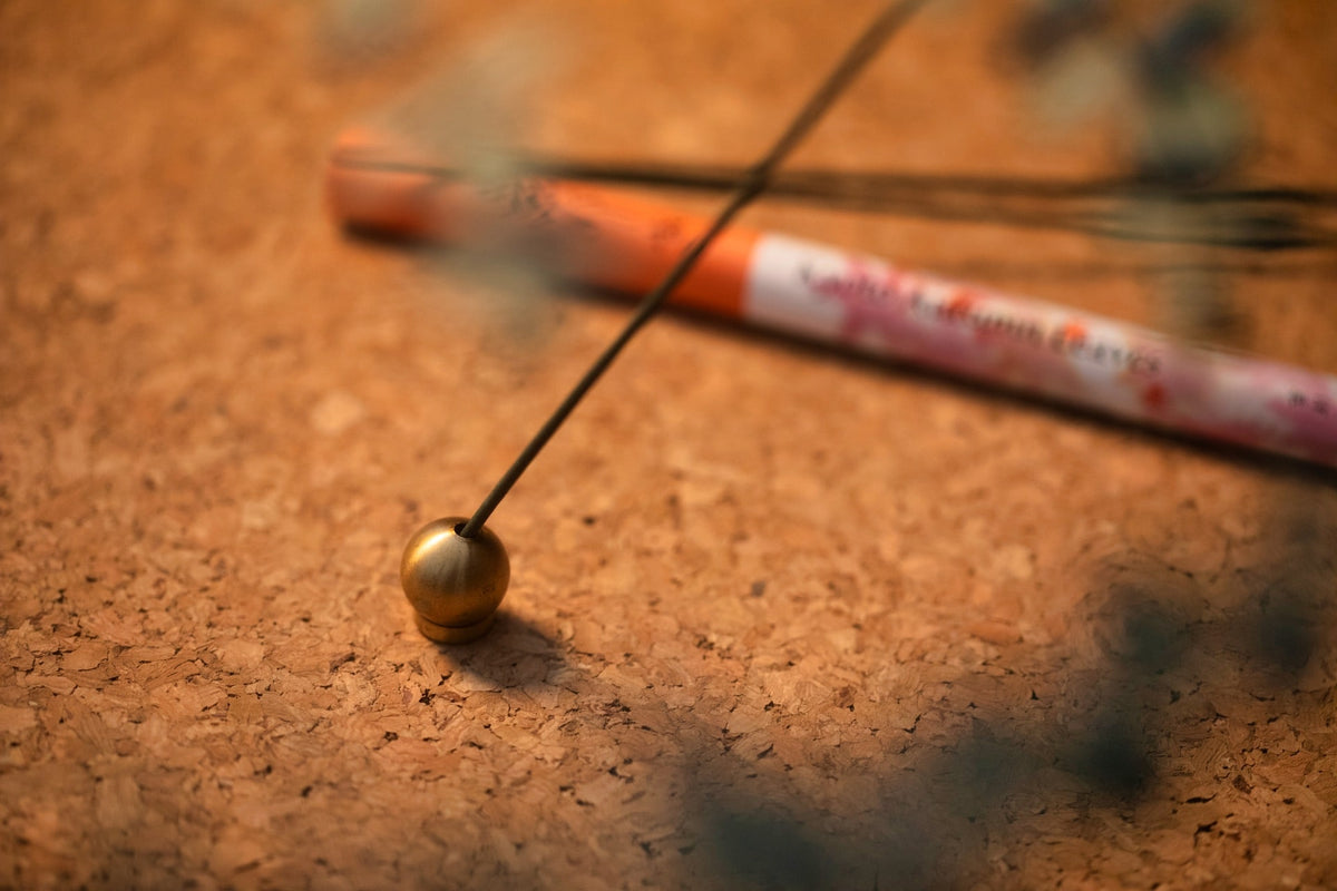 A Senko Brass Ball Incense Holder on a wooden table.