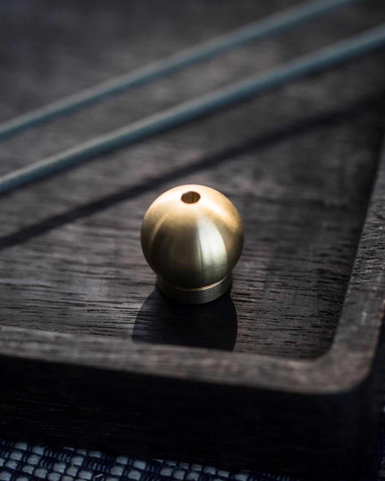 A small Senko Brass Ball Incense Holder sits on top of a black tray.