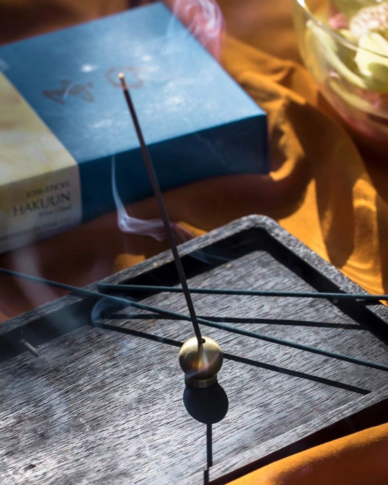 A small Senko Brass Ball Incense Holder sits on top of a black tray.