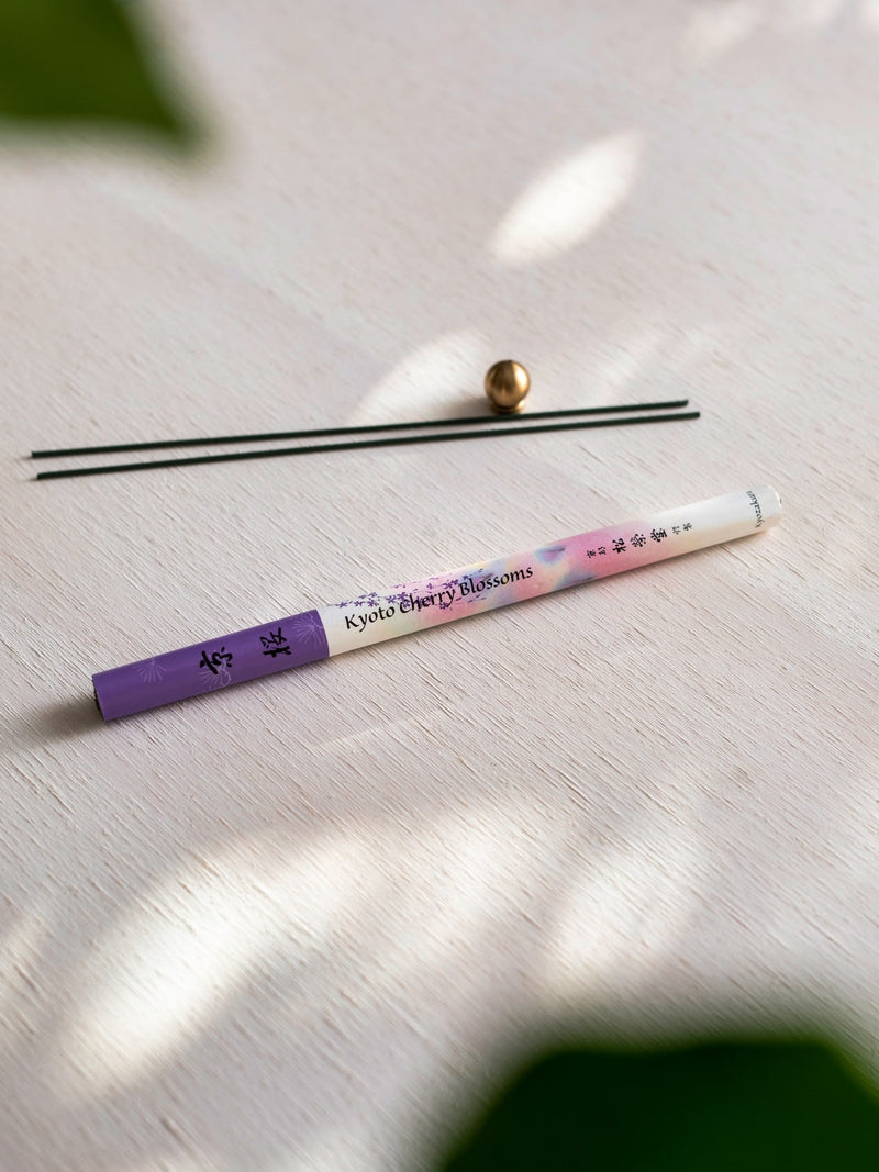 A Cherry Blossom – Kyozakura pencil with a purple flower on it next to a plant. (Brand: Senko)