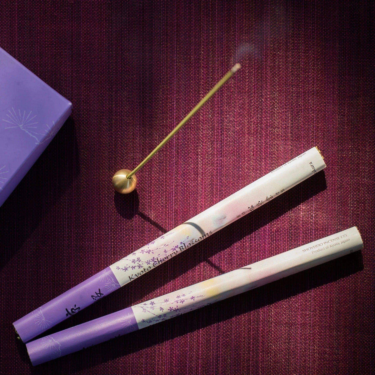 Three Cherry Blossom – Kyozakura incense sticks on a purple background. (Brand Name: Senko)