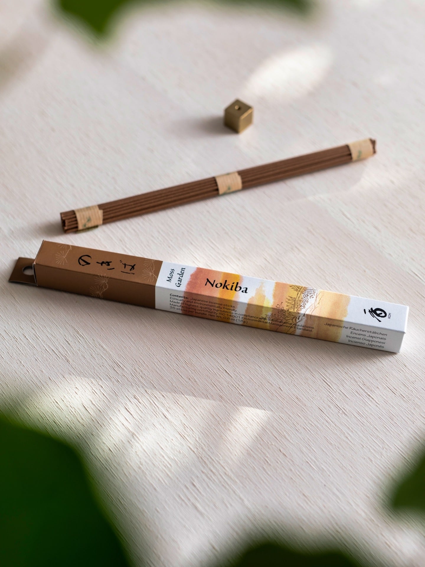 A pack of Moss Garden – Nokiba incense sticks on a wooden table by Senko.