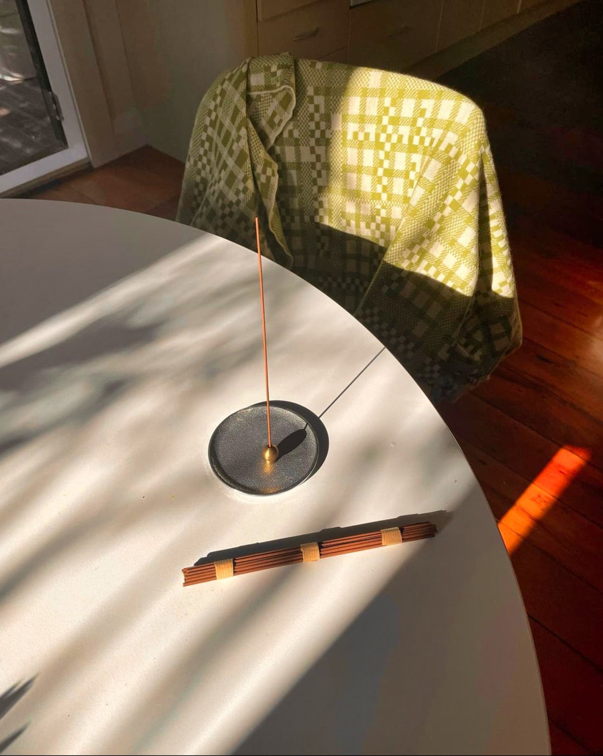 A Senko Brass Ball Incense Holder on a white table.