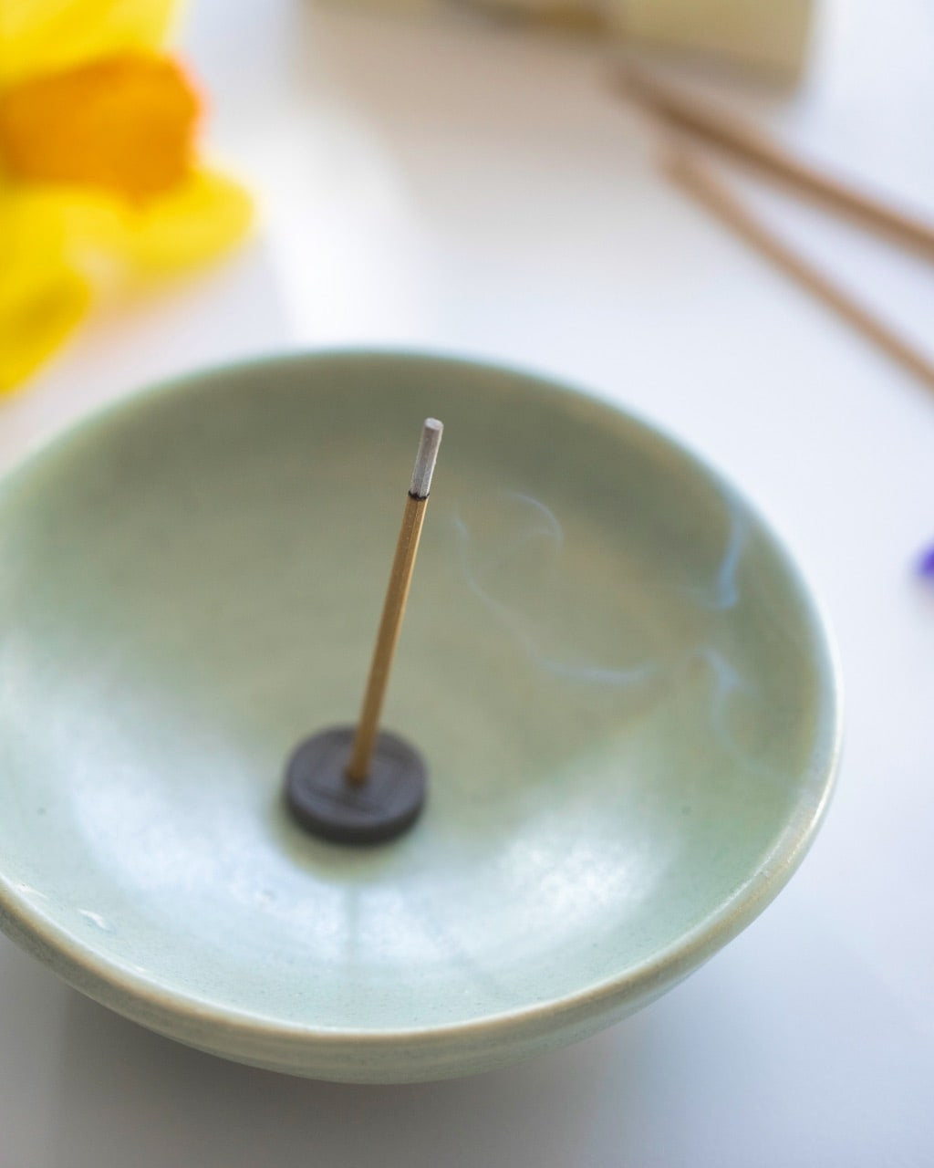 An Grapefruit with Holder – Xiang Do incense stick on top of a wooden table.