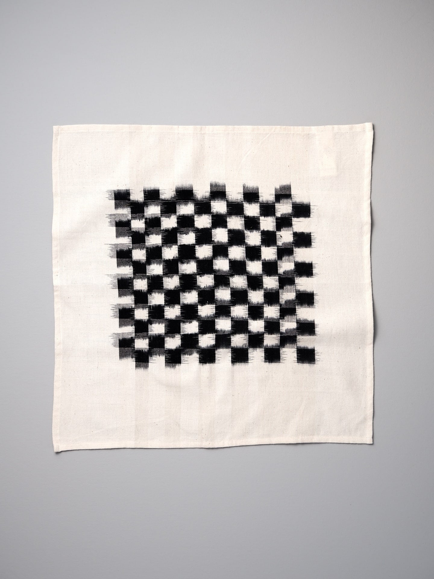 A Ikat Weave Napkins (set of 6) – Black Check cloth on a white background by Stitchwallah.