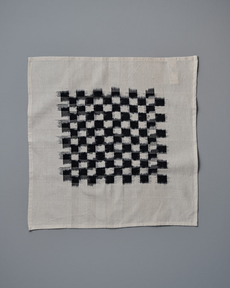 A Ikat Weave Napkins (set of 6) – Black Check cloth on a white background by Stitchwallah.