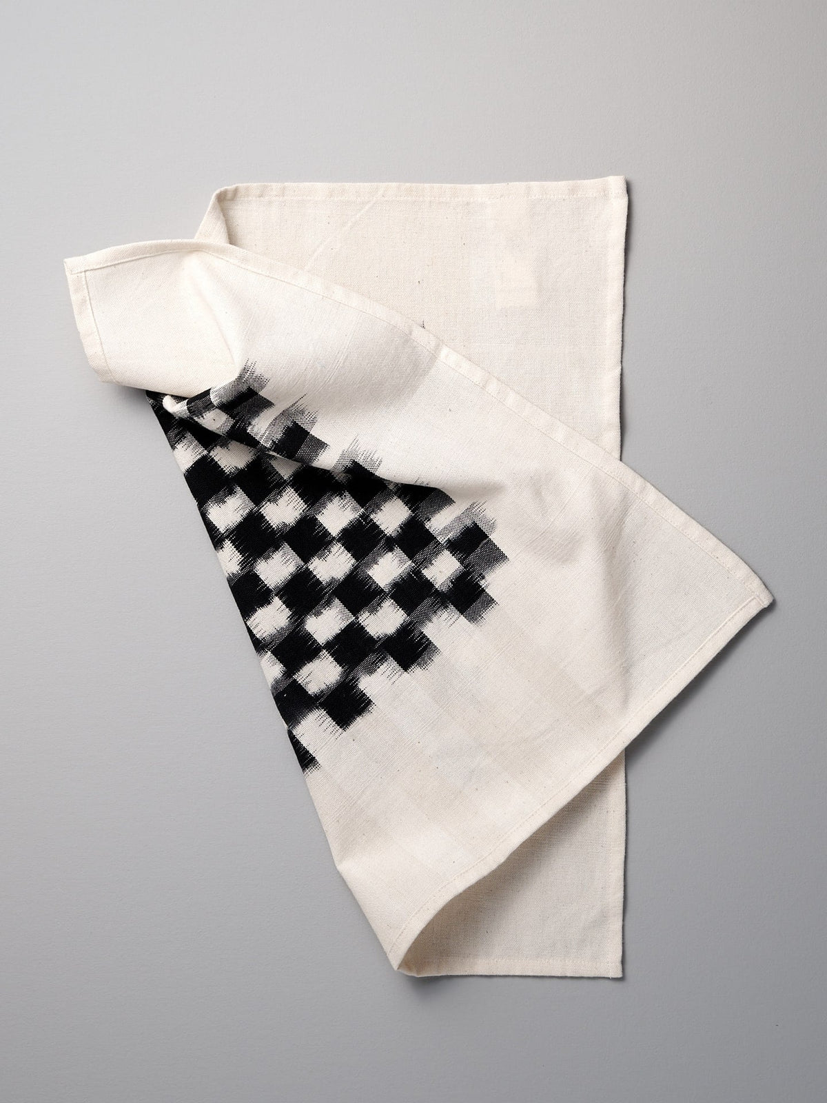 A Stitchwallah towel with a black and white checkered pattern.