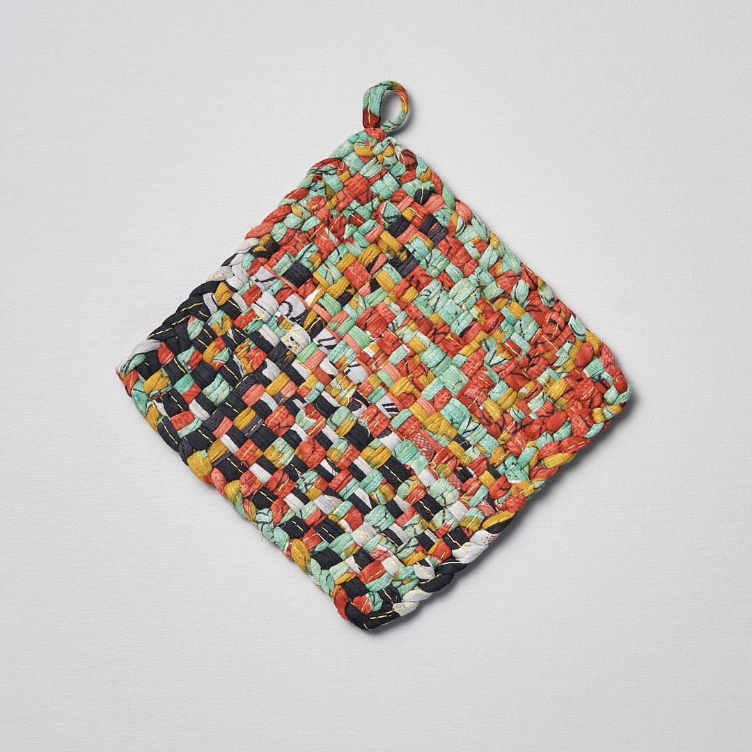 A colorful Sari Pot &amp; Oven-tray Holder by Stitchwallah on a white surface.