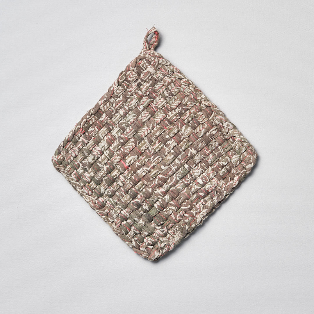 A Sari Pot &amp; Oven-tray Holder hanging on a white surface. (Brand: Stitchwallah)