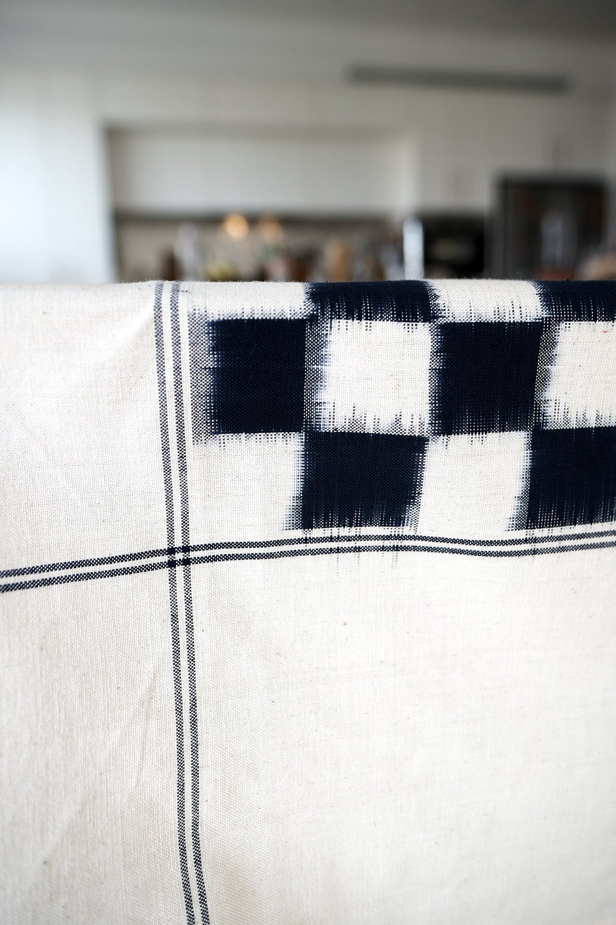 A Ikat Weave Tablecloth – Indigo Check by Stitchwallah with a checkered pattern on it.