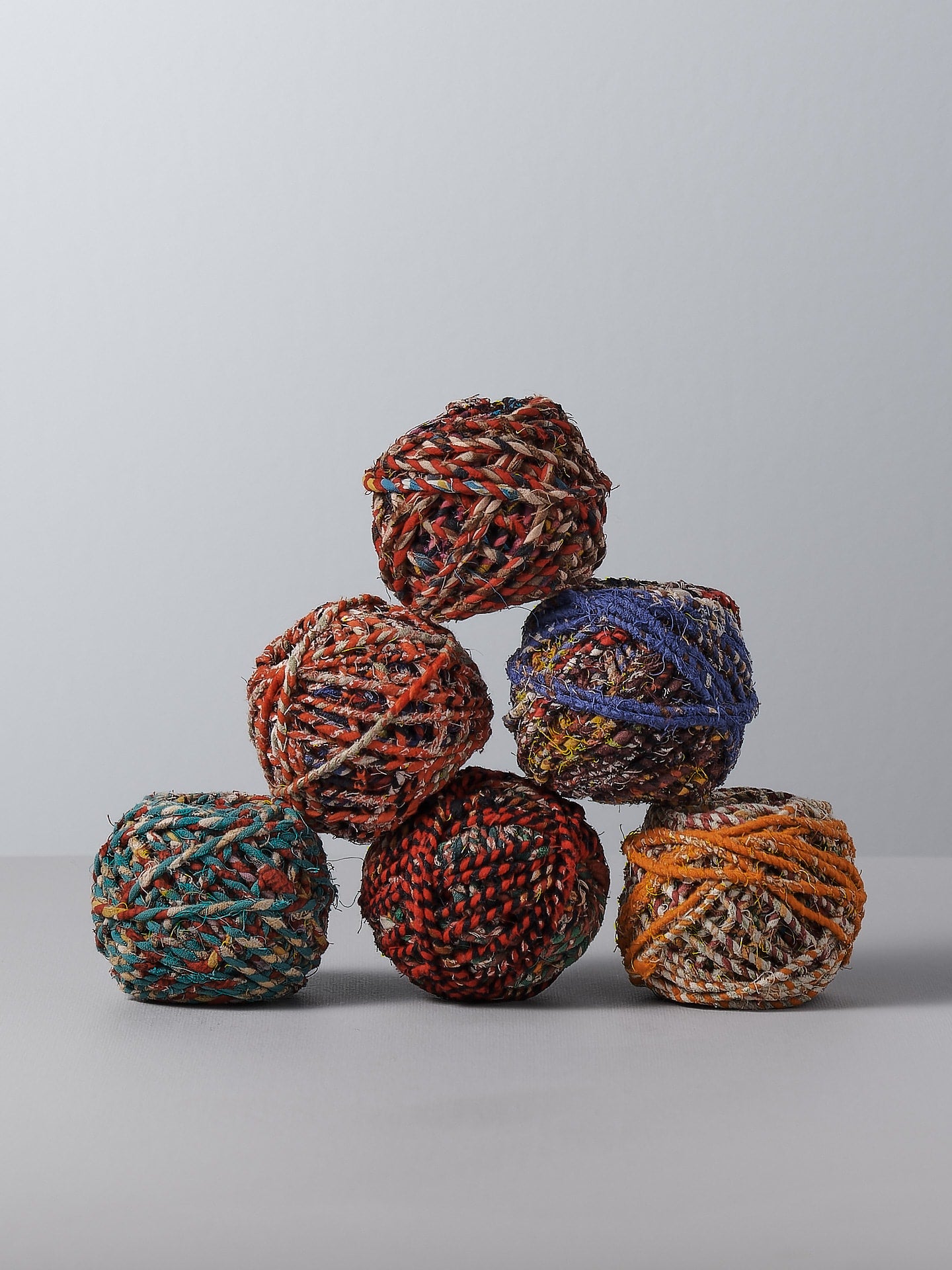 A group of Stitchwallah Recycled Sari Twine – 25𝗆 on a white surface.