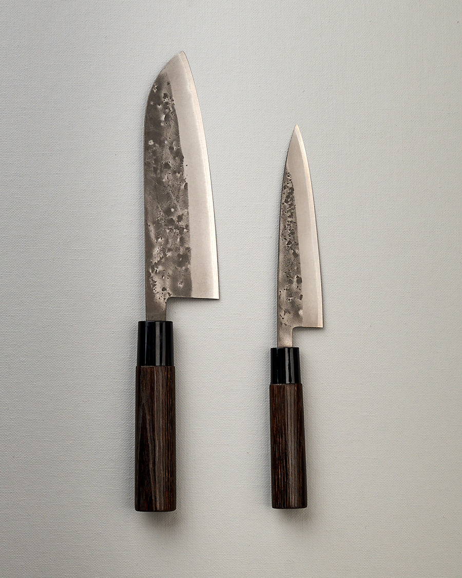 Two Tadafusa Bocho Petty Knives on a white surface next to each other.