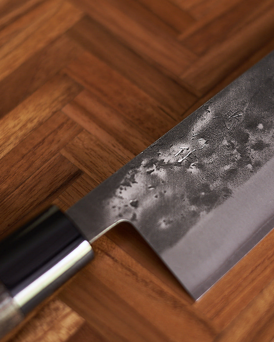 A Tadafusa Bocho Petty Knife in a box on a white surface.