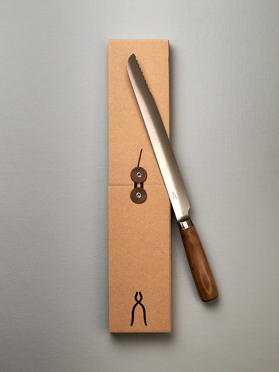 A Tadafusa Hocho Bread Slicer Knife is sitting on top of a box.