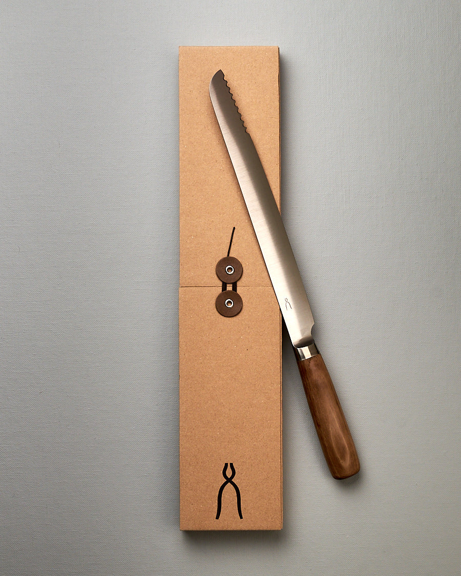 A Tadafusa Hocho Bread Slicer Knife is sitting on top of a box.