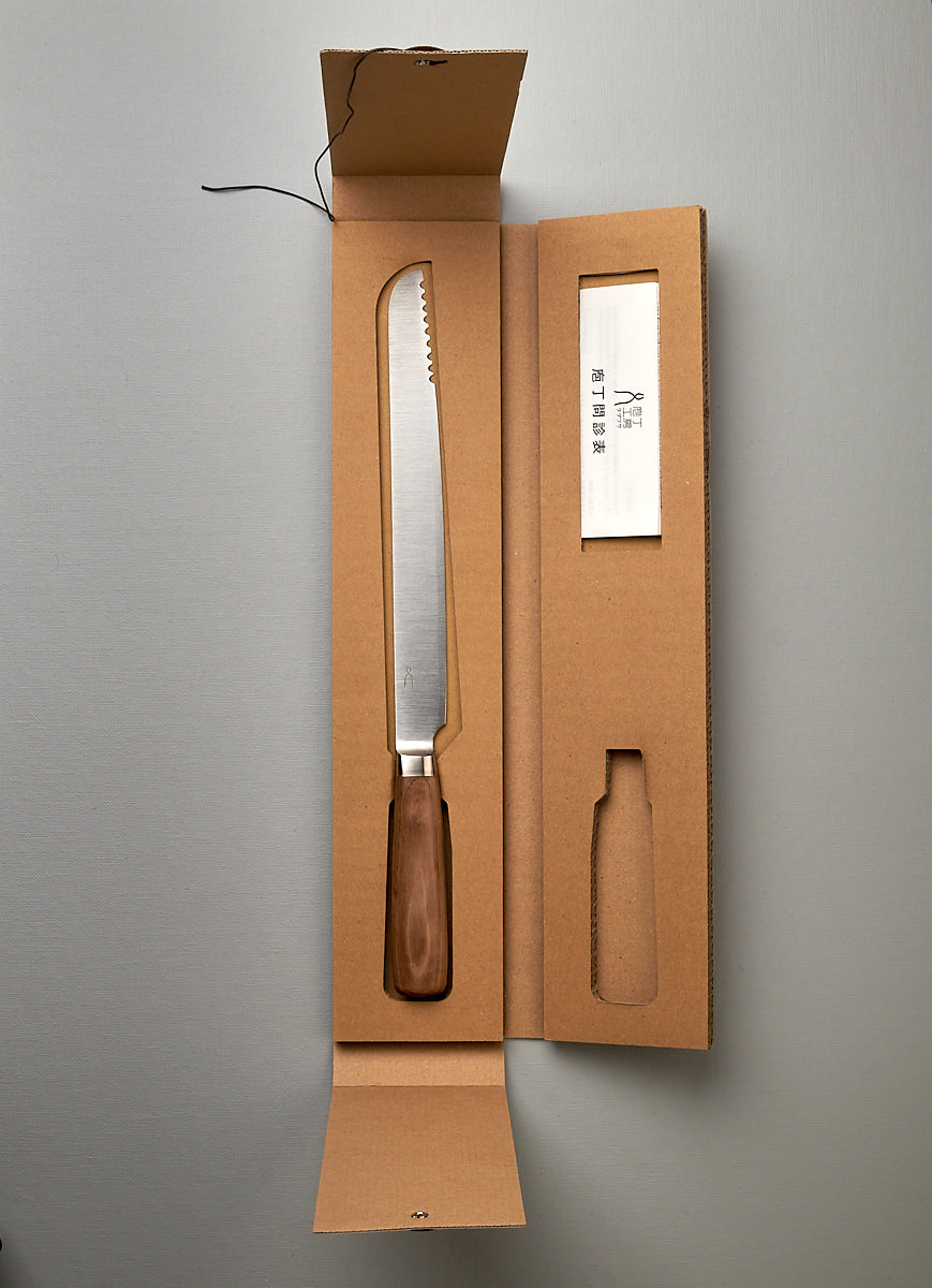 A Hocho Bread Slicer Knife in a cardboard box on a table, Tadafusa.
