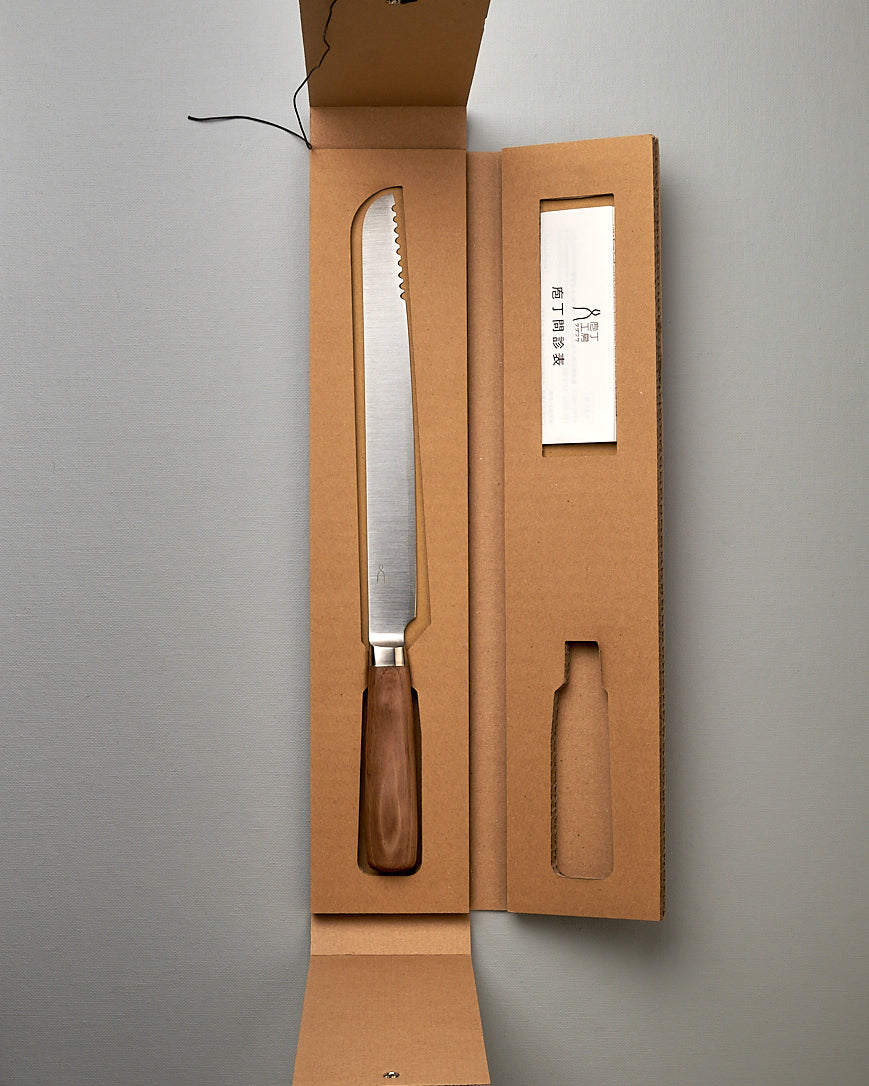 A Hocho Bread Slicer Knife in a cardboard box on a table, Tadafusa.