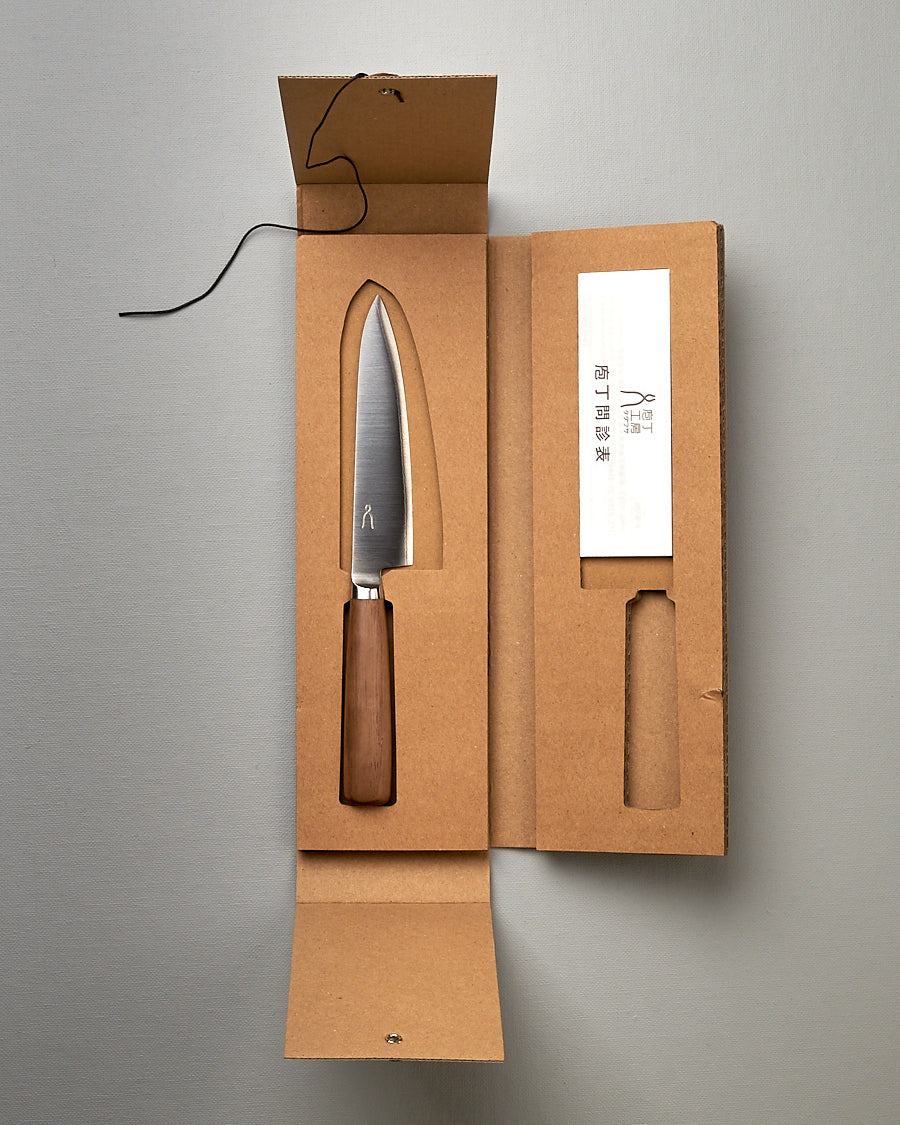 A Tadafusa Hocho Petty Knife in a cardboard box with a label on it.