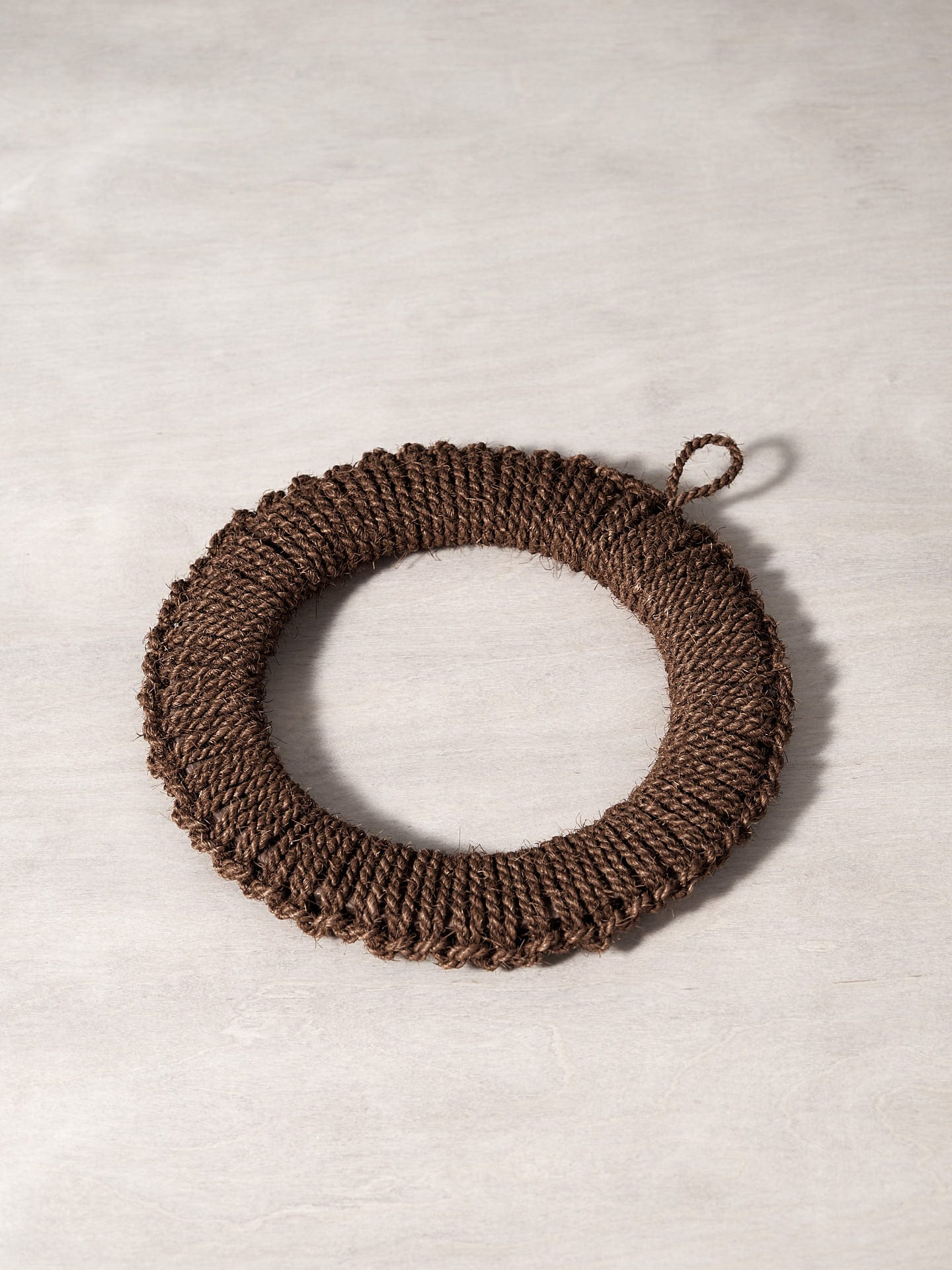 A Takada Hand-Knit Trivet – Large on a wooden surface.