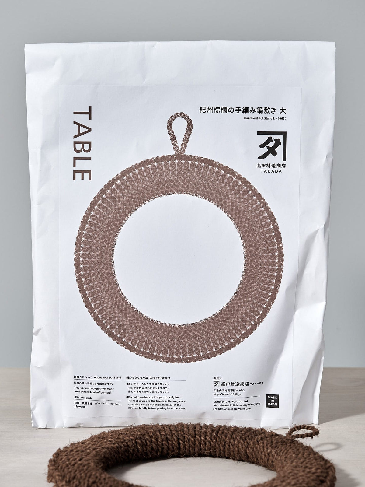 A bag of Hand-Knit Trivet – Large yarn with a crocheted ring on it by Takada.