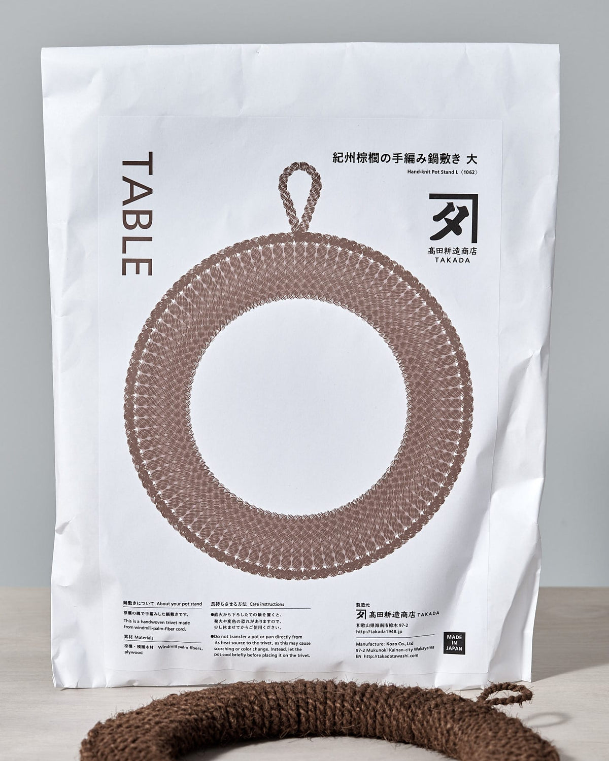 A bag of Hand-Knit Trivet – Large yarn with a crocheted ring on it by Takada.