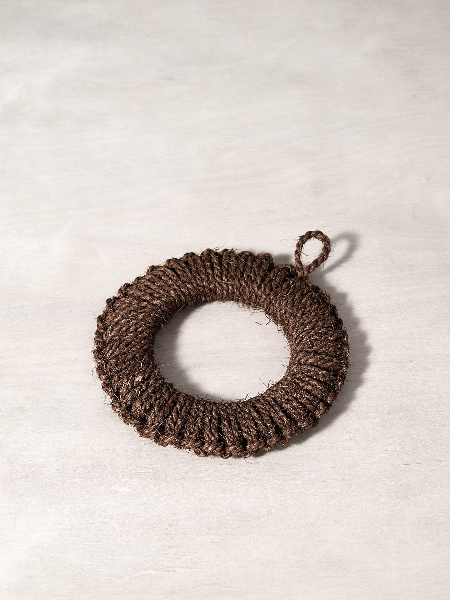 A Takada Hand-Knit Trivet – Medium on a white surface.