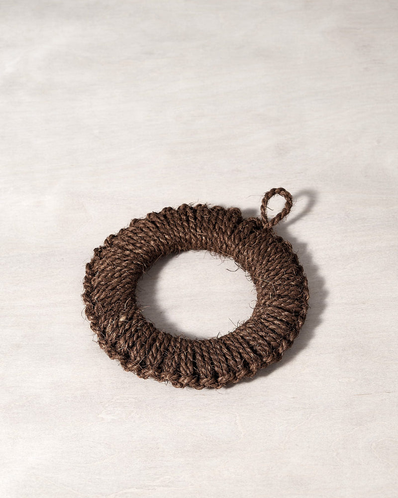 A Takada Hand-Knit Trivet – Medium on a white surface.
