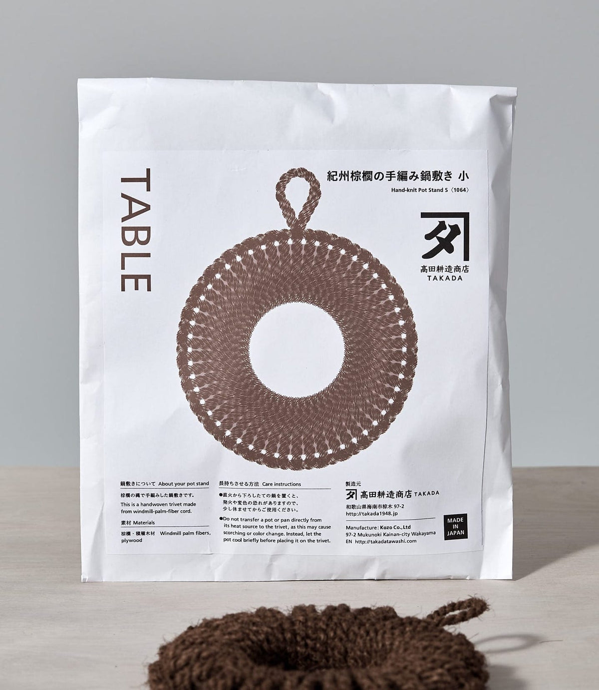 A bag of yarn with a Hand-Knit Trivet – Small by Takada on it.