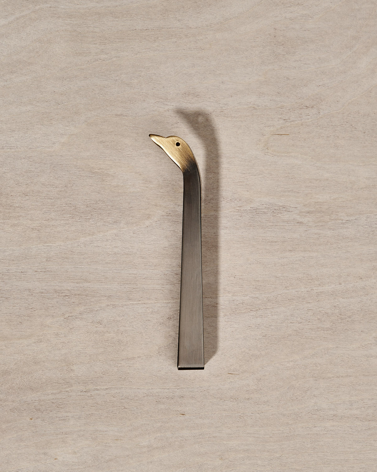 A Candle Snuffer Duck by Takazawa is sitting on top of a wooden surface.