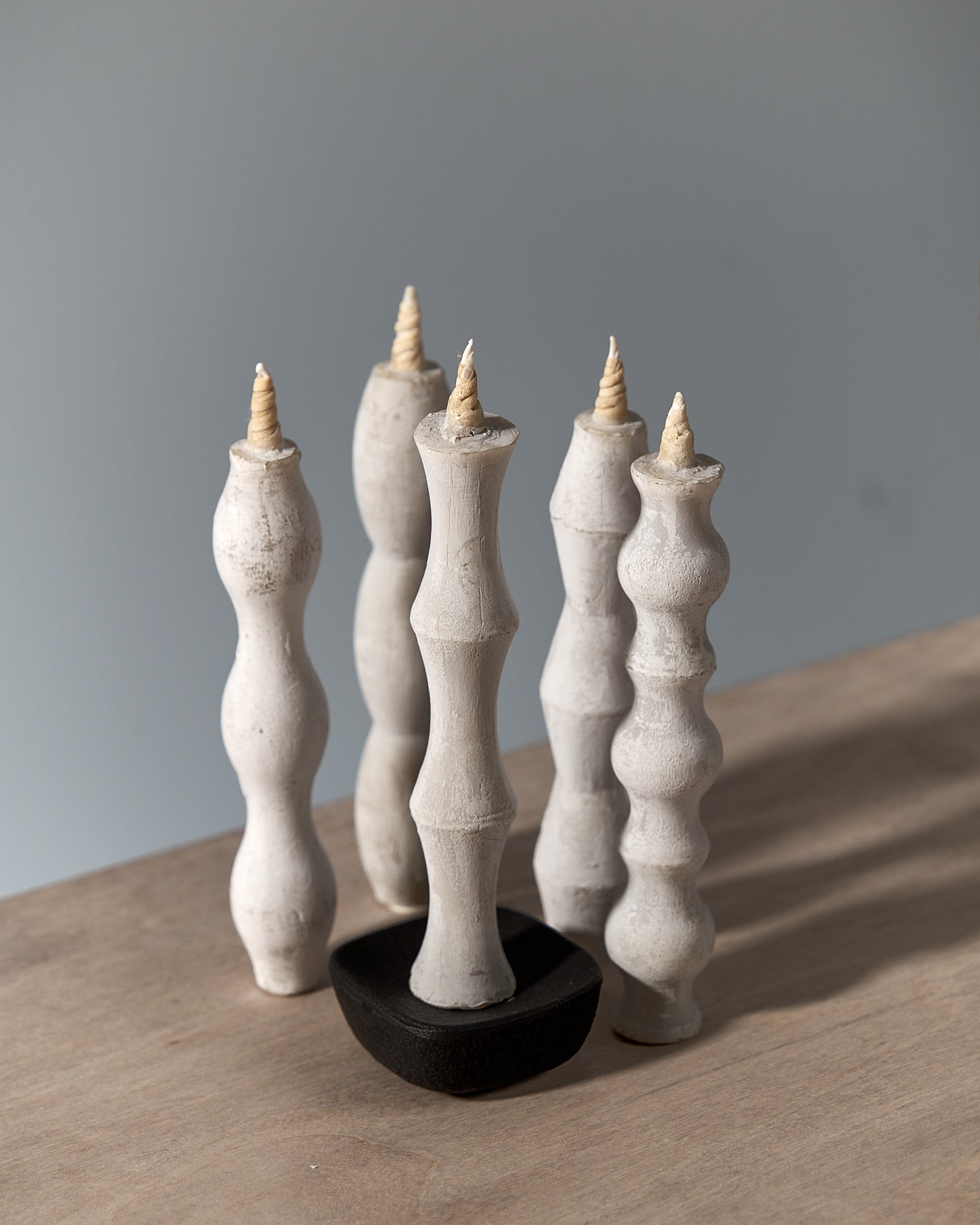 A NANAO-A candle sitting on top of a wooden table, manufactured by Takazawa.