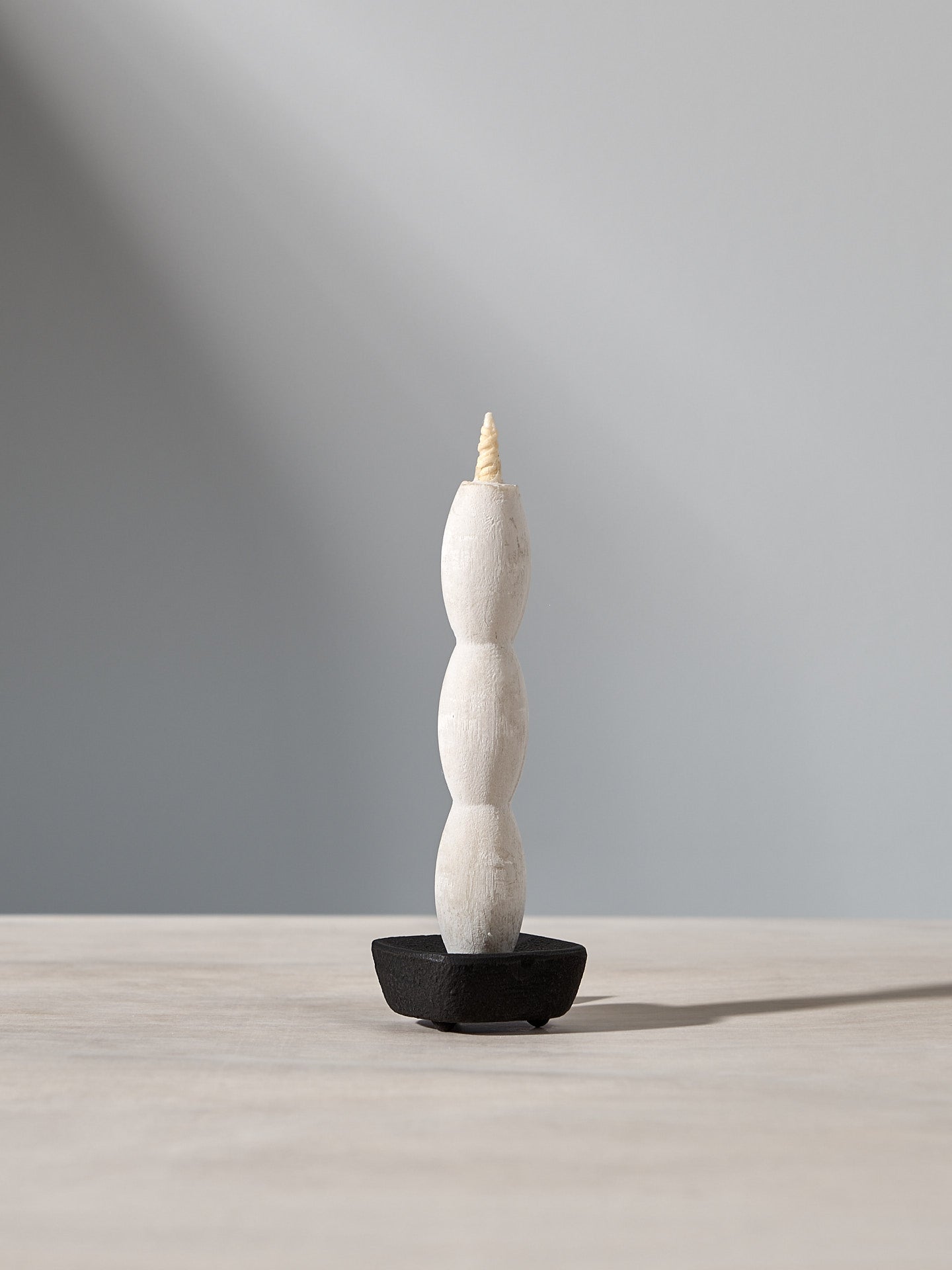 A NANAO-A candle sitting on top of a wooden table, manufactured by Takazawa.