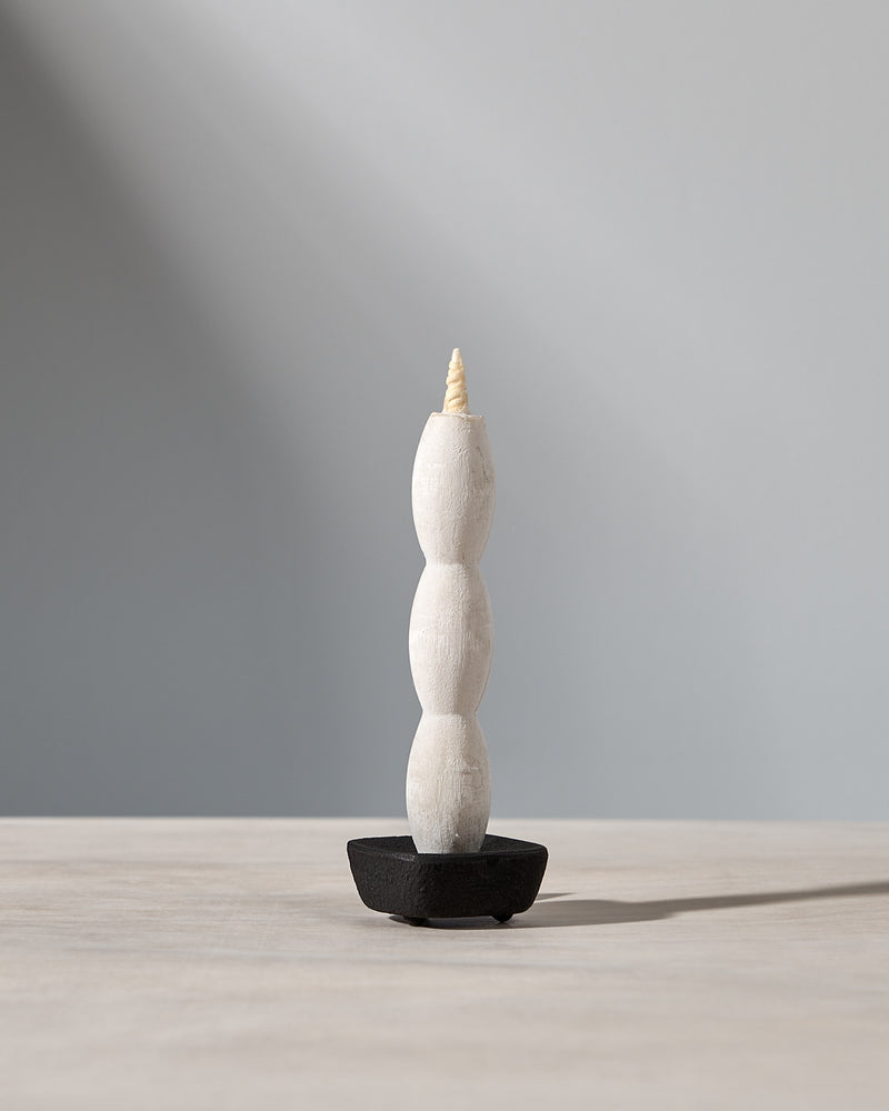 A NANAO-A candle sitting on top of a wooden table, manufactured by Takazawa.